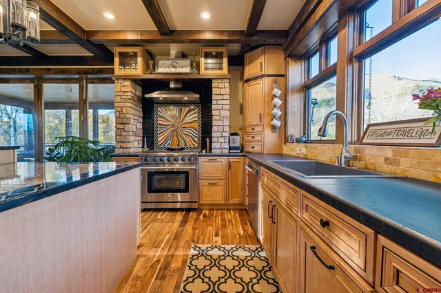 a large kitchen with granite countertop a stove and a large window