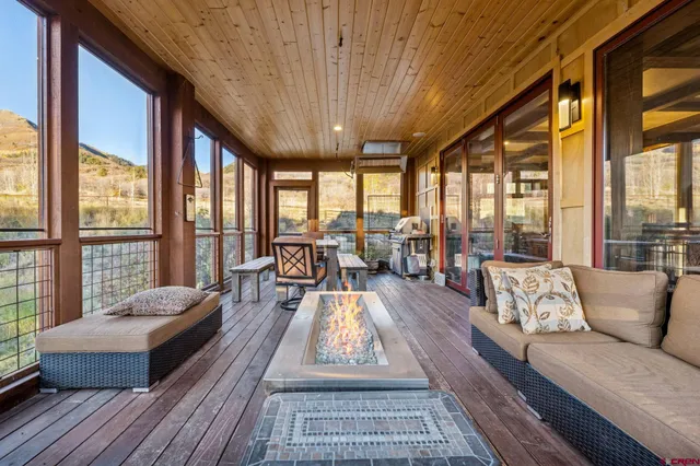 a living room with furniture and floor to ceiling windows