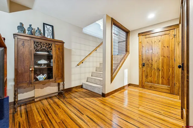 a view of a hallway with wooden floor and front door