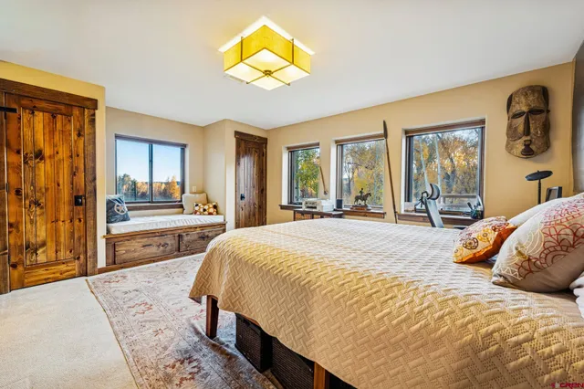 a spacious bedroom with a bed and painting on the wall