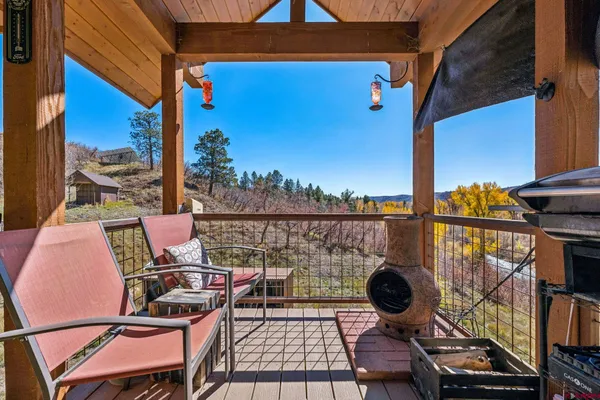 a view of a balcony with chairs and wooden floor