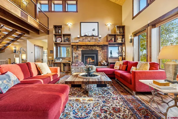 a living room with furniture fireplace and a large window
