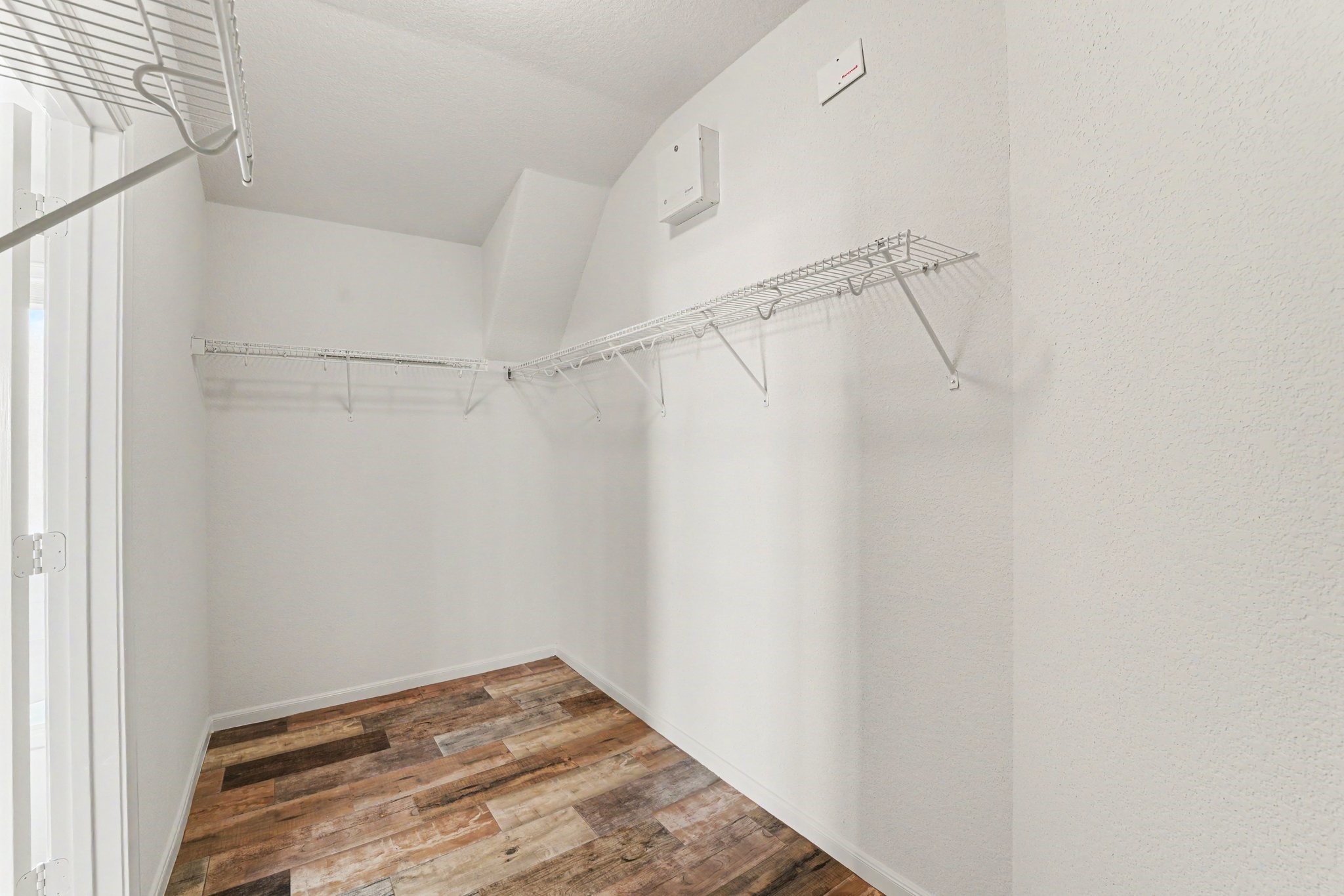 21427 Blooming Rock Lane Spring, TX 77379 - Photo 28 of 32 A spacious walk-in closet featuring white walls, wood-look flooring, and wire shelving for ample storage.