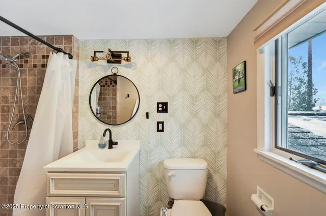 a view of an empty room with wooden floor and a fireplace
