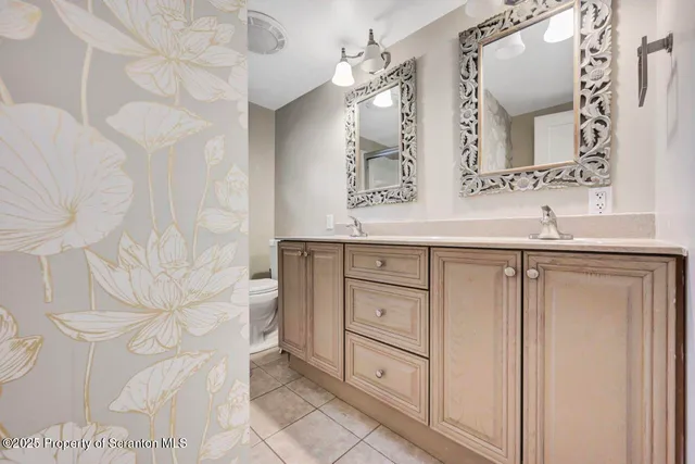 a bathroom with a sink vanity mirror and toilet