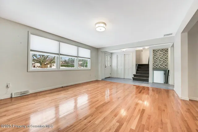 a big room with wooden floor and windows