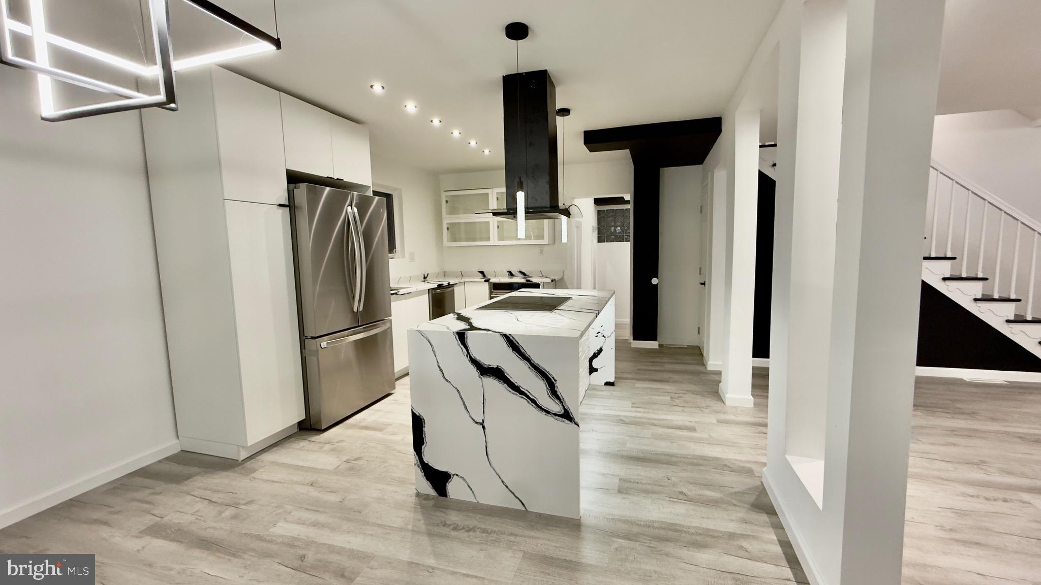 a view of a kitchen with refrigerator and an entryway