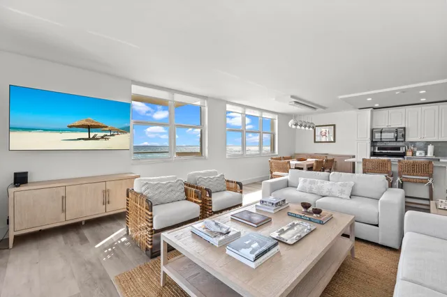 a living room with furniture a rug and kitchen view
