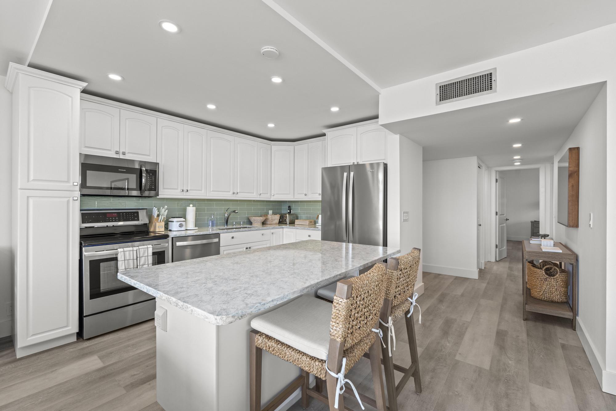 5440 North Ocean Drive, Unit 306 Singer Island, FL 33404 - Photo 19 of 43 a kitchen with stainless steel appliances granite countertop a refrigerator and a stove top oven