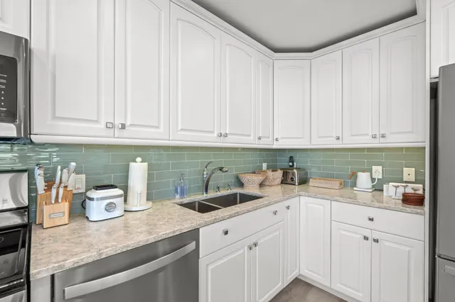 a kitchen with white cabinets and white appliances