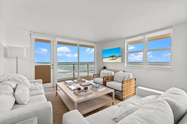 a living room with furniture a large window and a table