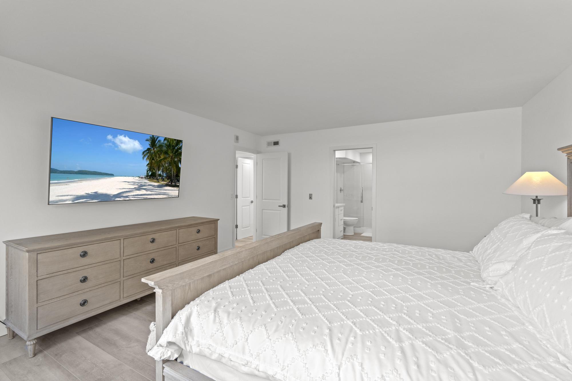 5440 North Ocean Drive, Unit 306 Singer Island, FL 33404 - Photo 26 of 43 a bedroom with a bed and a flat screen tv in it