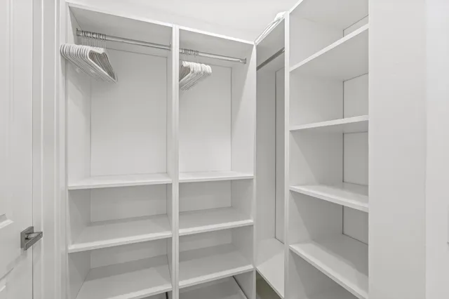 a view of walk in closet with empty racks