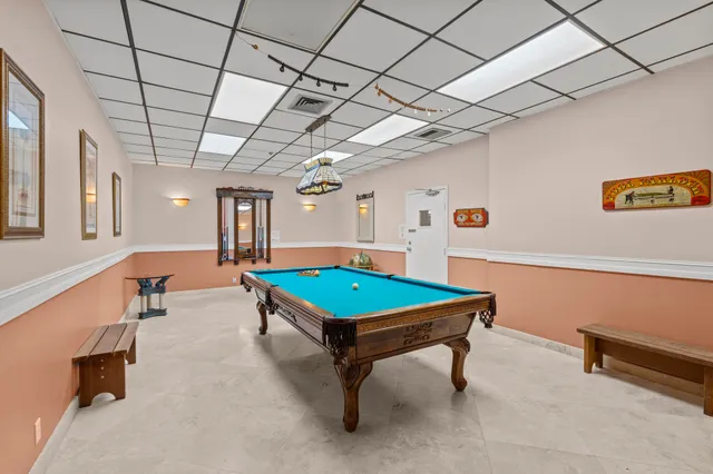 a room with pool tables windows and a table