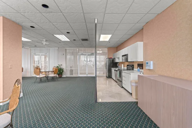 a view of a kitchen with kitchen island granite countertop lots of counter top space and stainless steel appliances