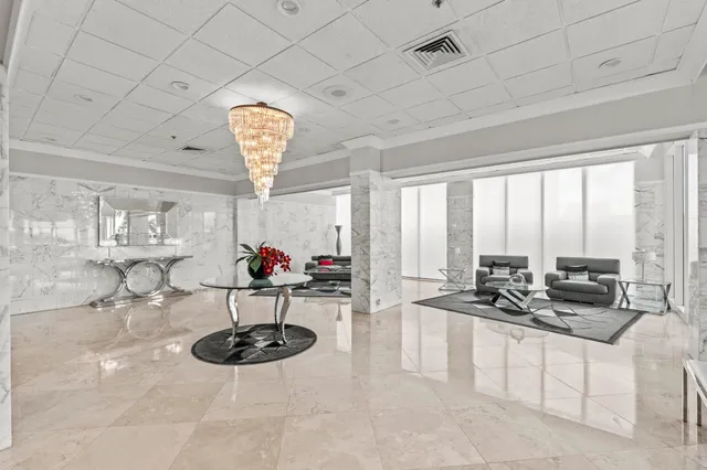 a room with lots of appliances a chandelier furniture and a large window