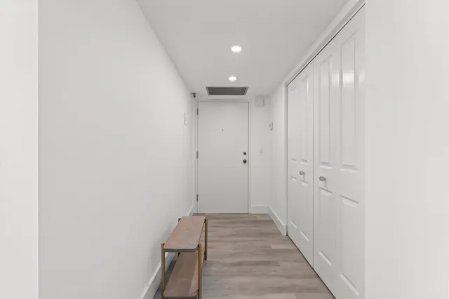 a view of a hallway with wooden floor