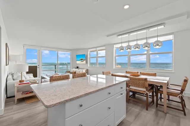 a room with a table chairs and a large window