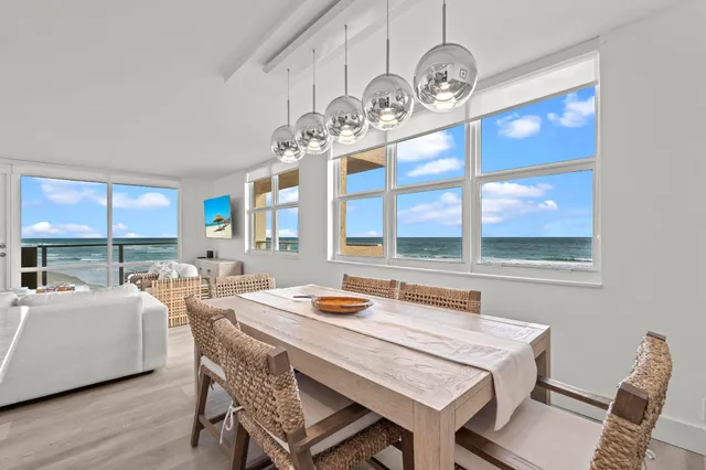a dining room with wooden floor a chandelier a wooden table and chairs