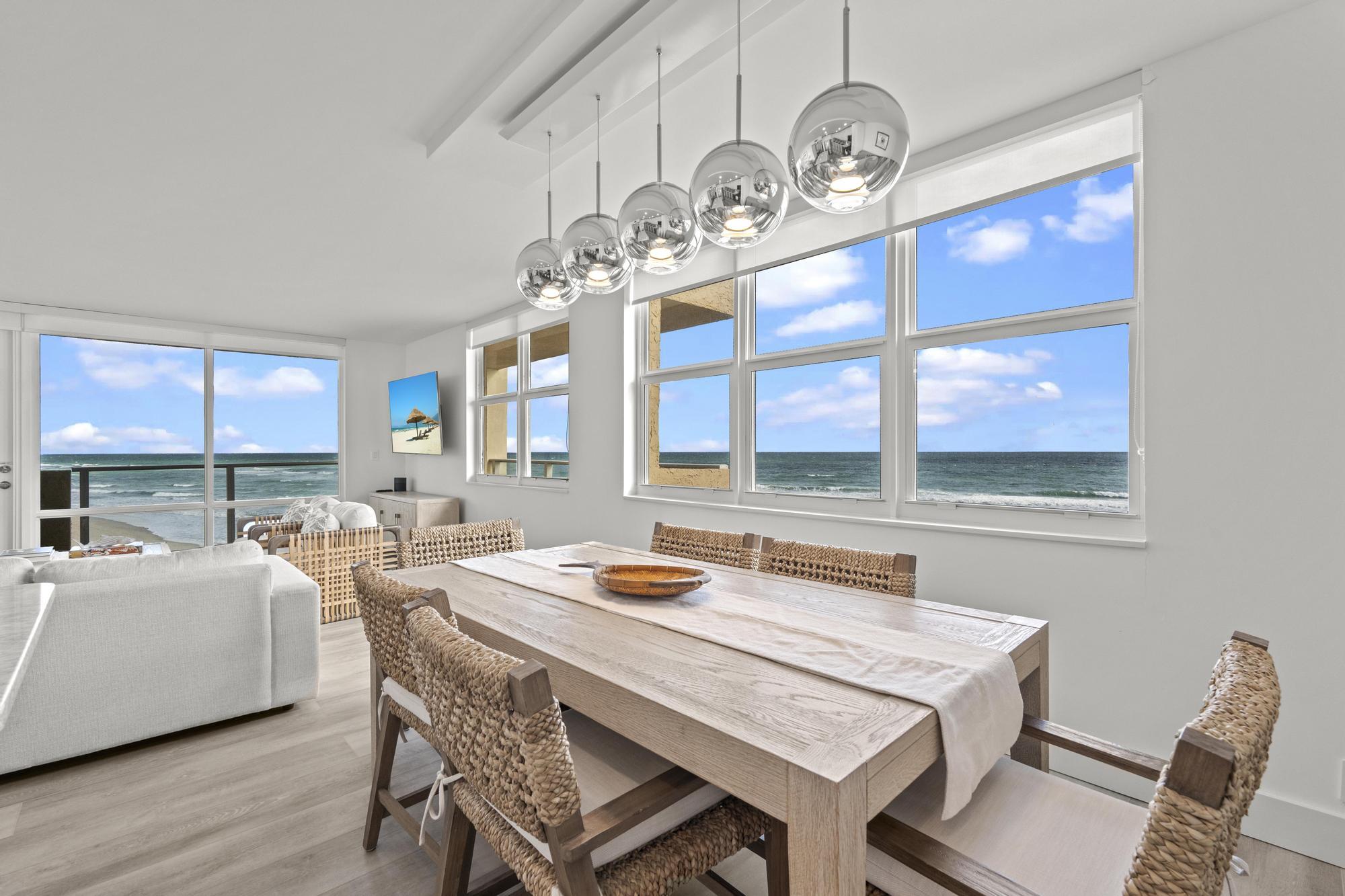 5440 North Ocean Drive, Unit 306 Singer Island, FL 33404 - Photo 9 of 43 a dining room with wooden floor a chandelier a wooden table and chairs