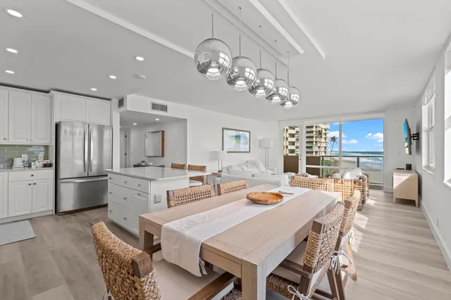 a open dining room with stainless steel appliances kitchen island granite countertop furniture and wooden floor