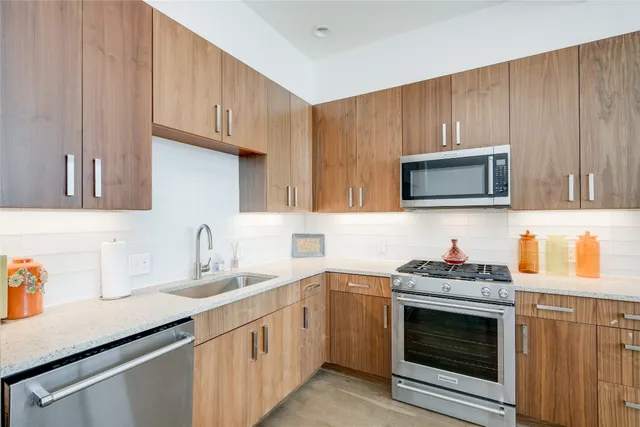 a kitchen with stainless steel appliances a stove microwave sink and cabinets