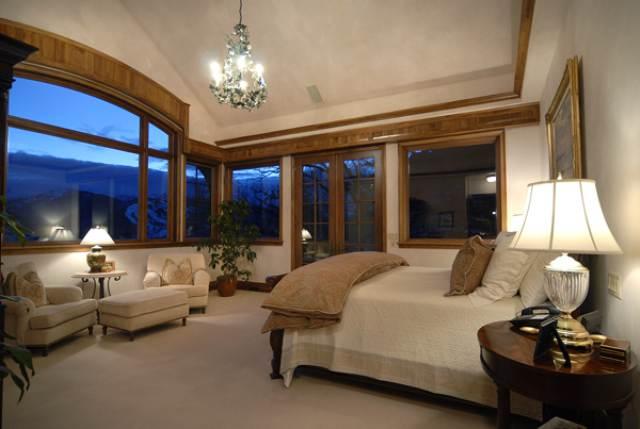 418 Wrights Road Aspen, CO 81612 - Photo 8 of 9 a spacious bedroom with a bed and a chandelier