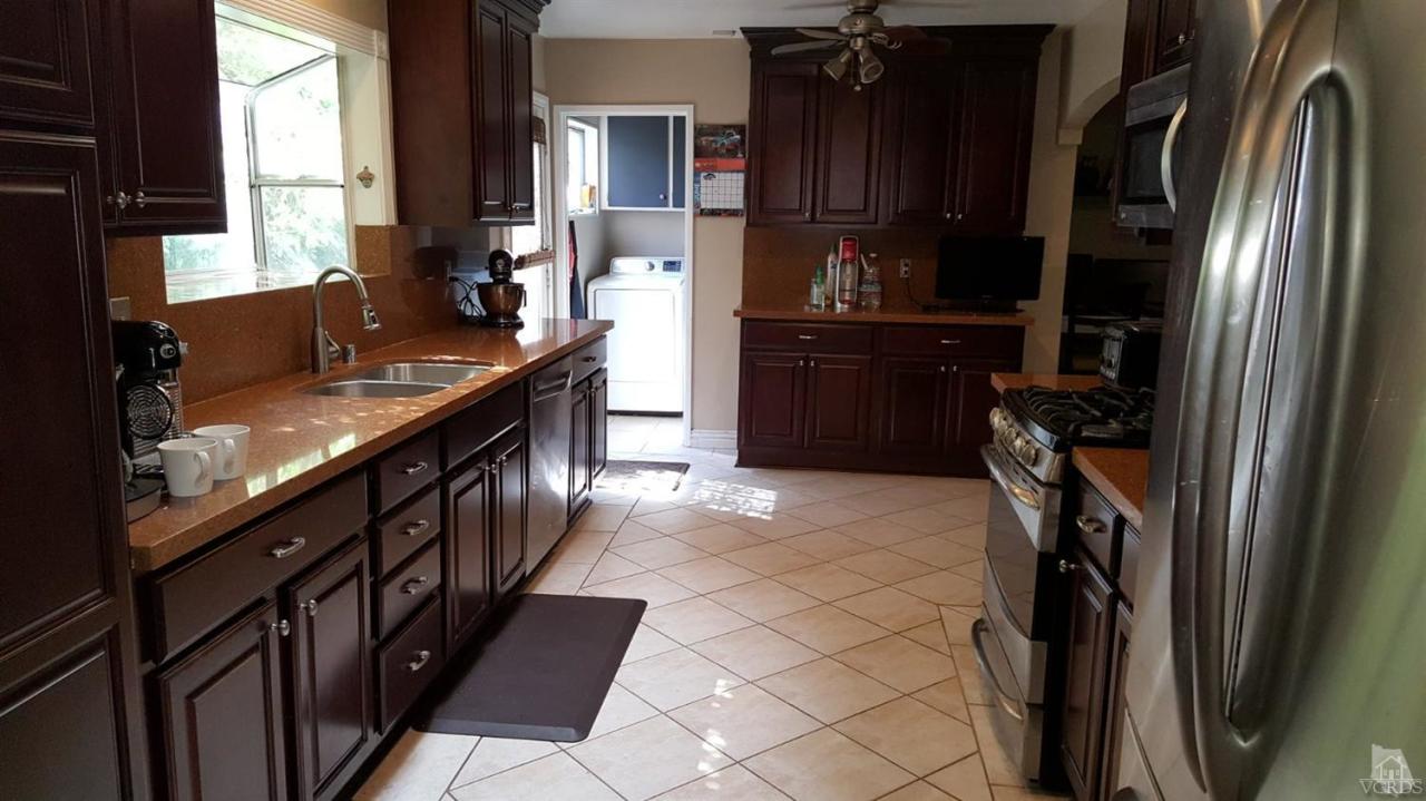6392 White Street Simi Valley, CA 93063 - Photo 7 of 30 a kitchen with granite countertop a refrigerator and a sink