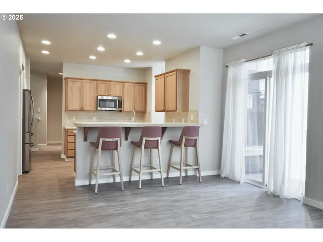 a kitchen with kitchen island granite countertop a refrigerator and a cabinets