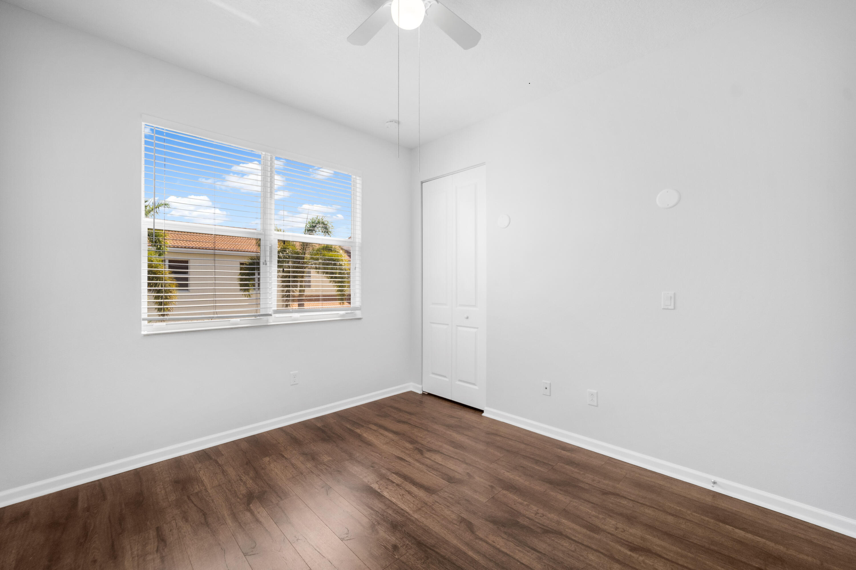 1430 Northwest 48th Lane Boca Raton, FL 33431 - Photo 19 of 54 a view of an empty room with wooden floor and a window