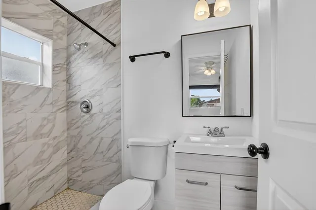 a bathroom with a sink mirror toilet and shower