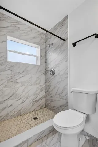 a bathroom with a toilet and a shower