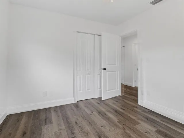 a view of an empty room and wooden floor