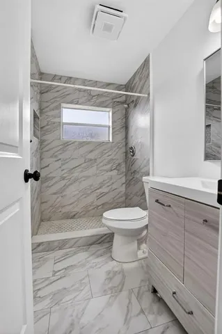 a bathroom with a toilet sink and shower