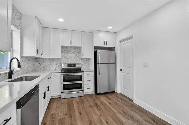 a kitchen with a refrigerator sink and cabinets