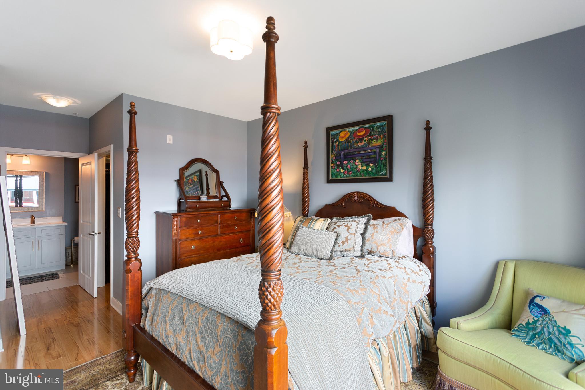 8005 13th Street, Unit 305 Silver Spring, MD 20910 - Photo 33 of 40 a bedroom with a bed and a dresser with mirror