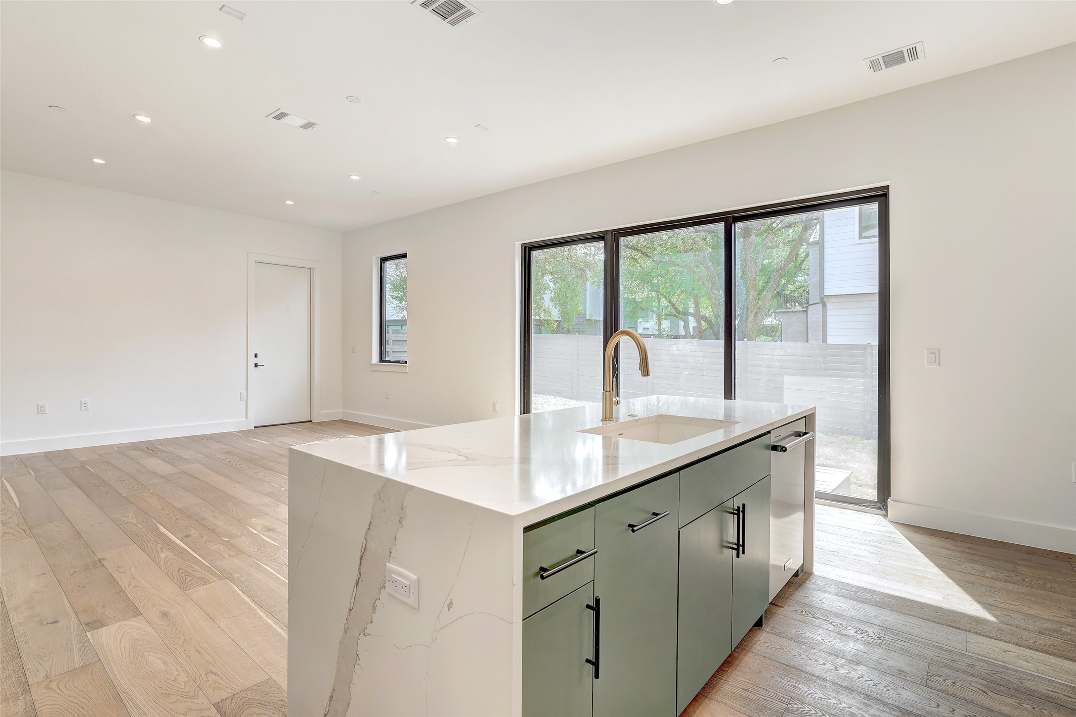 3208 Clawson Road, Unit 5A Austin, TX 78704 - Photo 32 of 34 Kitchen featuring light wood-style floors, recessed lighting, an island with sink, light stone counters, and open floor plan