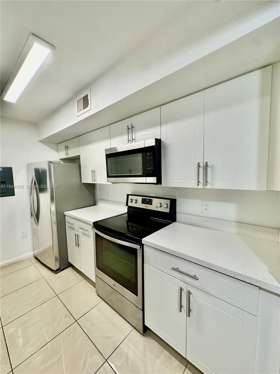 10440 Southwest 156th Court, Unit 722 Miami, FL 33196 - Photo 3 of 23 a kitchen with a stove and a refrigerator