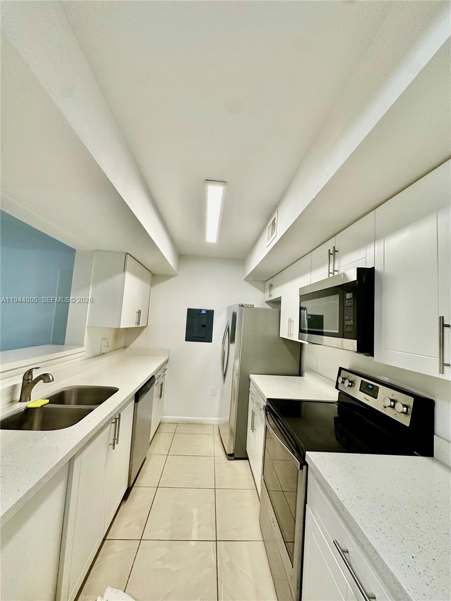 10440 Southwest 156th Court, Unit 722 Miami, FL 33196 - Photo 4 of 23 a kitchen with stainless steel appliances a sink a stove and a refrigerator