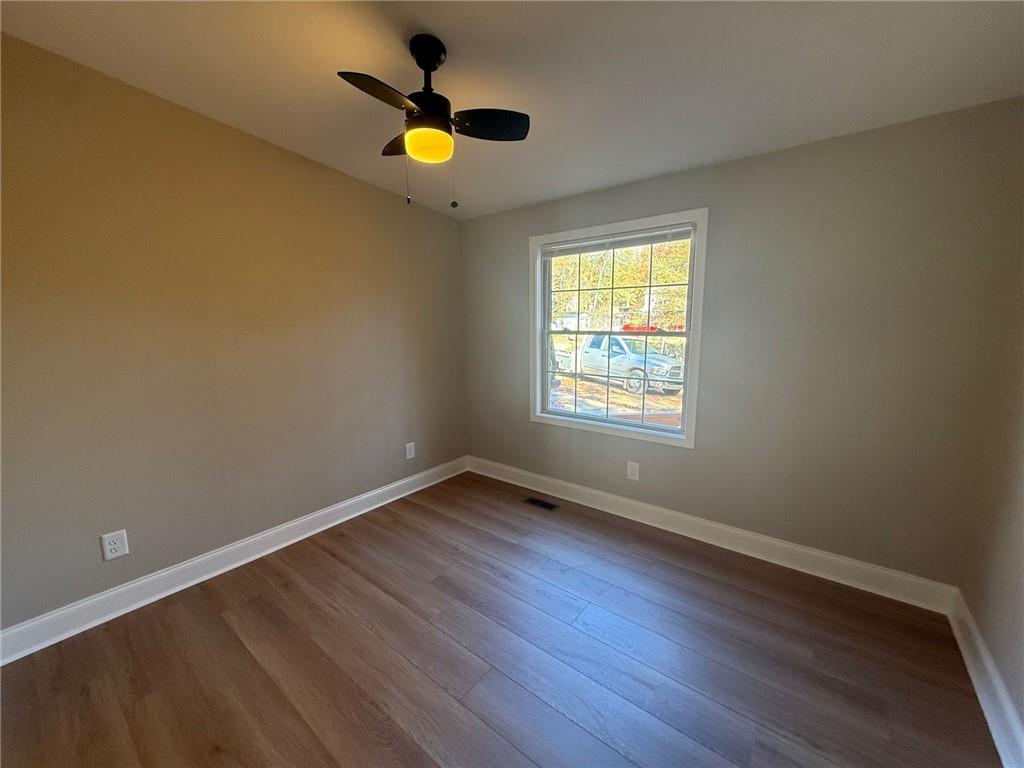 3726 Bolding Road Flowery Branch, GA 30542 - Photo 4 of 8 a view of an empty room with wooden floor and window