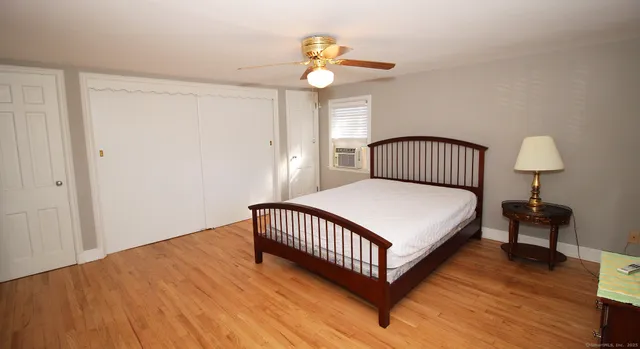 a bedroom with a bed and a flat tv screen on dresser
