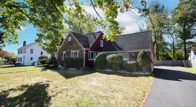a front view of a house with a yard covered with snow