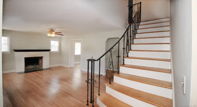 a view of a livingroom with wooden floor and a fireplace