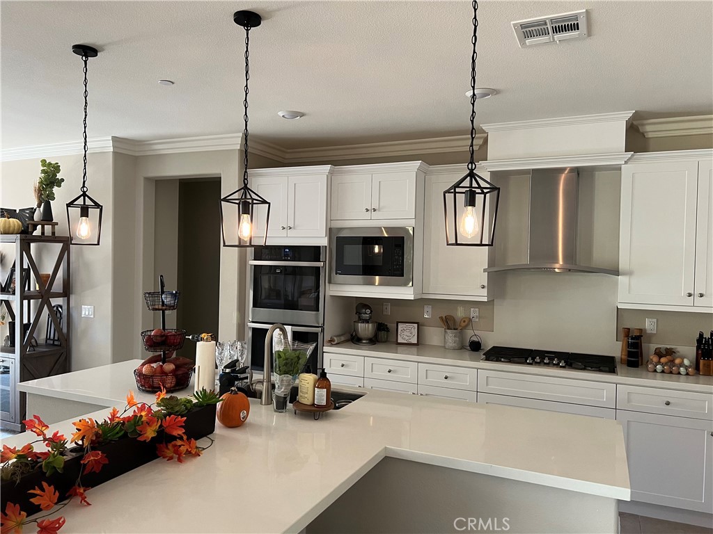 45766 Altree Court Temecula, CA 92592 - Photo 3 of 13 a kitchen with stainless steel appliances granite countertop a sink a stove and a refrigerator