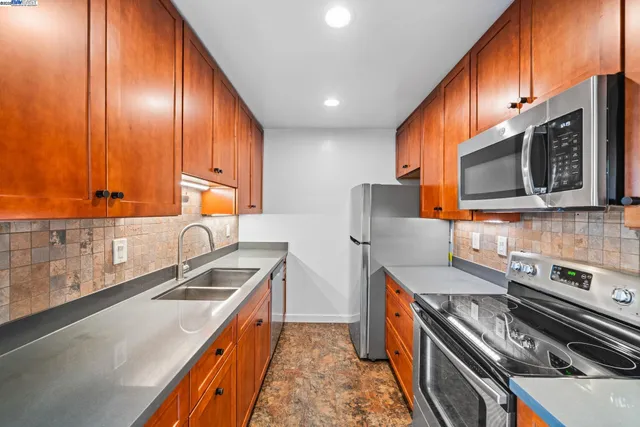 a kitchen with stainless steel appliances a stove a microwave and a sink