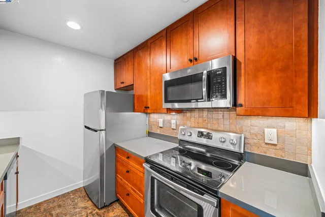 a kitchen with stainless steel appliances granite countertop a sink a stove and a refrigerator