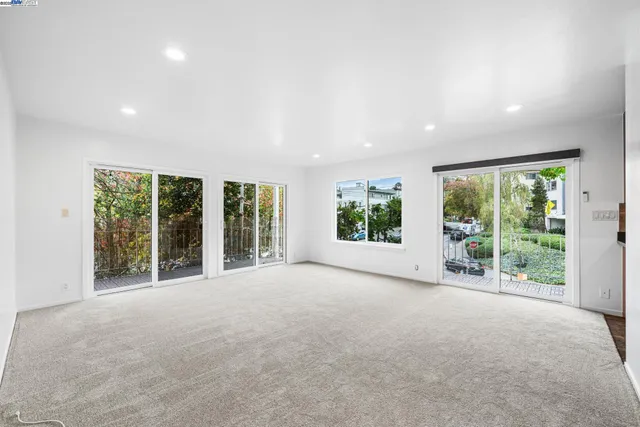 a view of an empty room with wooden floor and garden