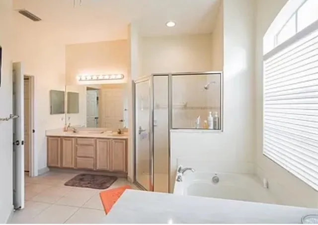 a bathroom with a tub sink shower and mirror
