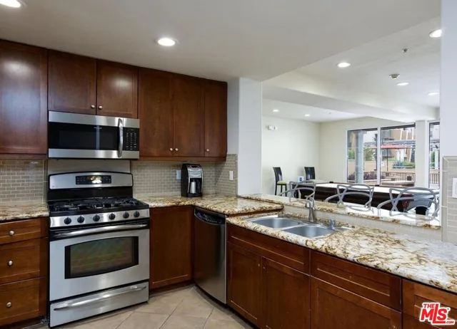a kitchen with sink a stove and cabinets