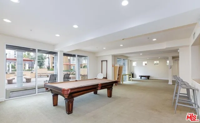 a room with pool table and windows